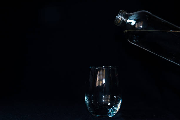 istock glass with water bottle, black background 1389602721