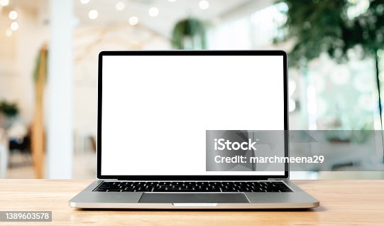 istock Laptop blank screen on wood table with blurred coffee shop cafe interior background and lighting bokeh, mockup, template for your text, Clipping paths included for background and device screen 1389603578