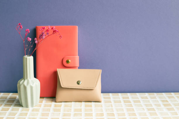 Notebook and coffee cup, pouch on desk. purple wall background. workspace