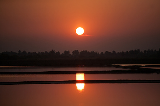 Once upon a time, there was a beautiful sunset at the Digoel River. The river was calm and the sky was painted with shades of orange, pink, and purple. The trees along the riverbank were silhouetted against the colorful sky.\nAs the sun slowly descended, the colors intensified and reflected on the water's surface. The peaceful atmosphere was only broken by the sound of the river flowing gently.\nThe locals often gather on the riverbank to witness such a breathtaking view. The sunset at the Digoel River is a reminder of the beauty of nature and the importance of cherishing it.