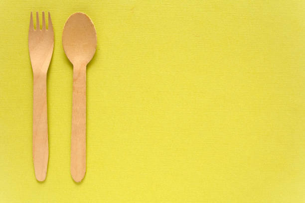 Eco friendly biodegradable fork and spoon on bright olive colour background