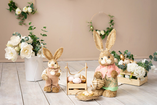 Easter hay bunnies: mother and son in an Easter decorative composition, eggs, flowers.