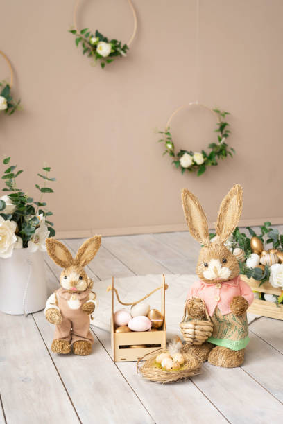 istock Easter hay bunnies: mother and son in an Easter decorative composition, eggs, flowers. 1389612995
