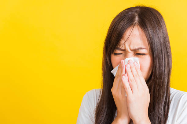 istock Woman sneezing sinus using towel to wipe snot from nose 1389614255