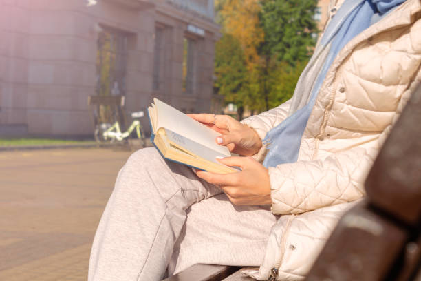 istock Woman reading book in park. Autumn mood 1389616701