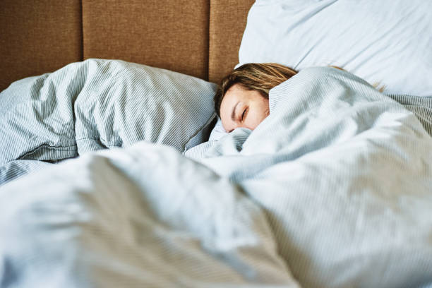 istock Woman sleeping in bed 1389621385