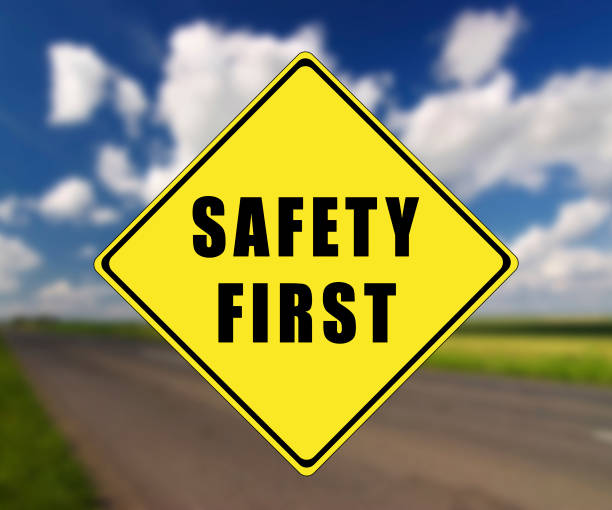 istock Road with yellow traffic sign safety first text on it 1389622213