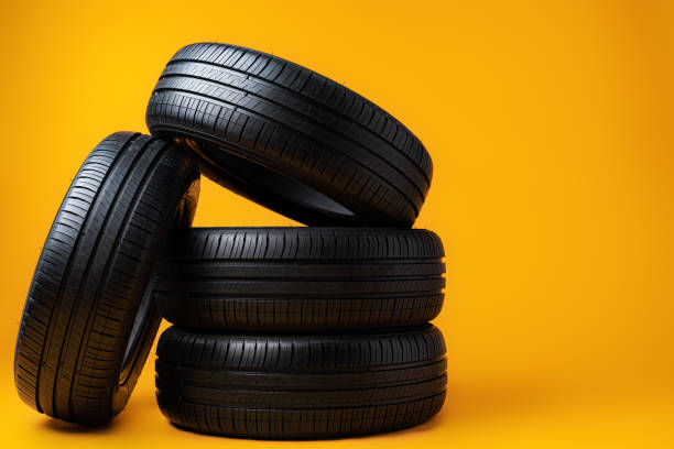 istock Car tires isolated on yellow background, close up 1389623886