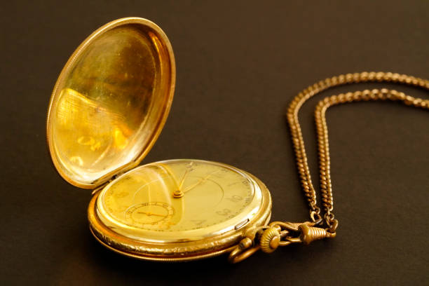 istock Old gold plated pocket watch against a black background. 1389625799