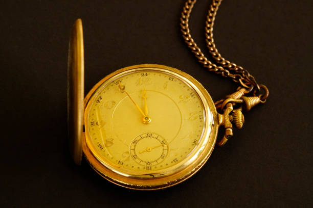 istock Old gold plated pocket watch against a black background. 1389625802