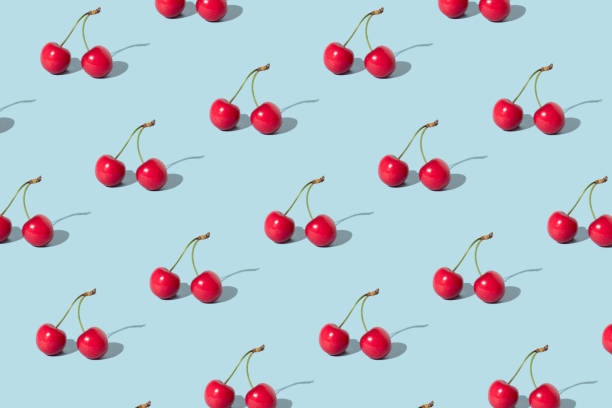 istock Creative pattern made with  red cherries on pastel blue background. Summer or spring fruit  concept. Minimal aesthetic idea. 1389626808