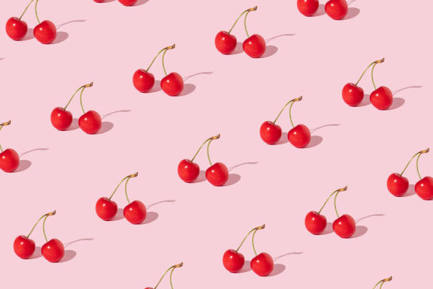 istock Creative pattern made with  red cherries on pastel pink background. Summer or spring fruit  concept. Minimal aesthetic idea. 1389626832