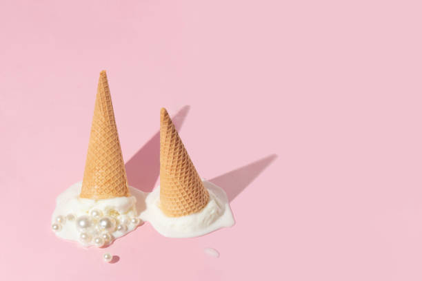 istock Creative layout with two ice cream cones up side down and vanilla ice cream scoops with pearls on pastel pink background. Summer aesthetic idea. Trendy food lay out. 1389627410