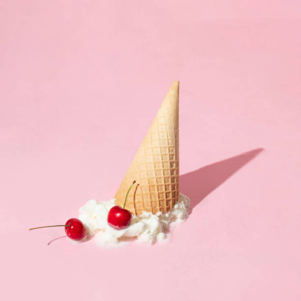 istock Creative layout with ice cream cone up side down and vanilla ice cream scoop with two bright red cherries on pastel pink background. Summer dessert and fruit aesthetic idea. Trendy food lay out. 1389627437