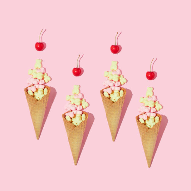 istock Creative composition or pattern with ice cream cones, yellow and pink gummy bears and bright red cherries on pastel pink background. Summer dessert art direction. Summer food aesthetic idea. 1389627462