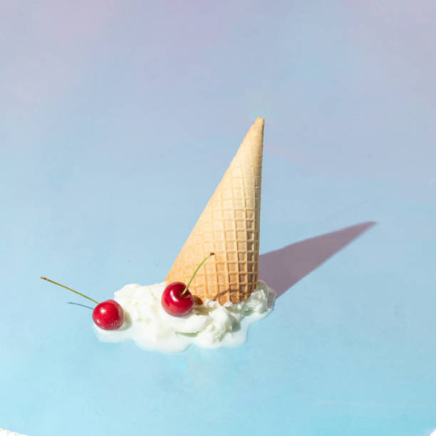 istock Creative layout with ice cream cone up side down and vanilla ice cream scoop with two bright red cherries on pastel blue background. Summer dessert and fruit aesthetic idea. Trendy food lay out. 1389627463