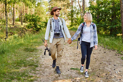 Young couple walking together in the woods holding hands