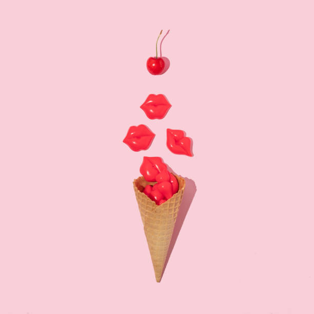 istock Creative composition with ice cream cone, bright red lips figurine and bright red cherry on pastel pink background. Summer dessert art direction. Summer food romantic idea. 1389627631