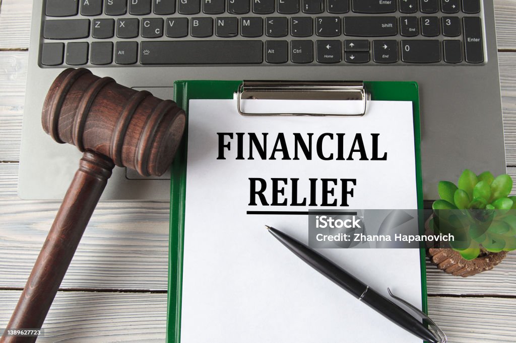FINANCIAL RELIEF - words on a white sheet on the background of a laptop, a court hammer and a pen FINANCIAL RELIEF - words on a white sheet on the background of a laptop, a court hammer and a pen. Business concept Accountancy Stock Photo