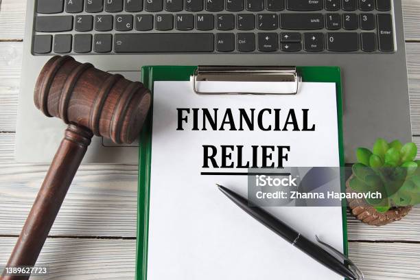 Financial Relief Words On A White Sheet On The Background Of A Laptop A Court Hammer And A Pen Stock Photo - Download Image Now