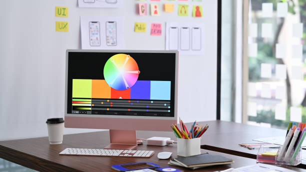 istock Design studio with computer, color swatches and wireframe sketches for mobile application on wooden table. 1389628981