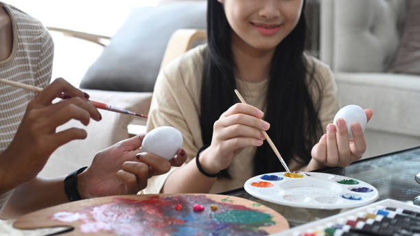istock Happy girl coloring Easter eggs with watercolors. Easter holidays concept. 1389629012
