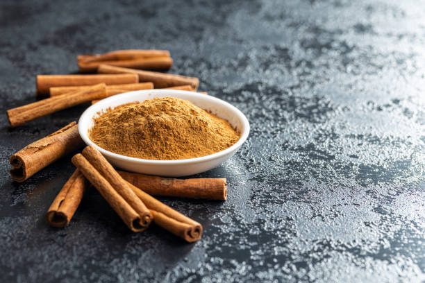 istock Dry cinnamon sticks and cinnamon powder on black table. 1389629605