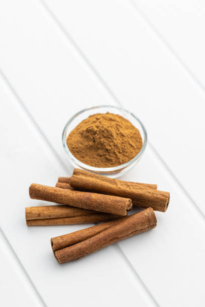 istock Dry cinnamon sticks and cinnamon powder on white table. 1389629611