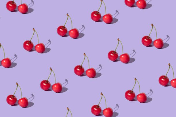 istock Creative pattern made with  red cherries on pastel purple background. Summer or spring fruit  concept. Minimal aesthetic idea. 1389629800