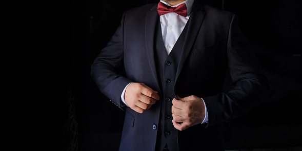 Close up a man in a suit with red bow on a black background. Copy space for your text.