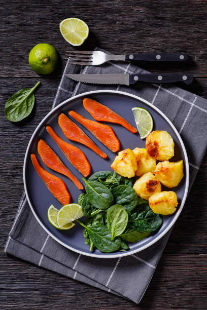 salmon slices with spinach leaves, roast potatoes - smoked salmon salt healthy lifestyle cold imagens e fotografias de stock
