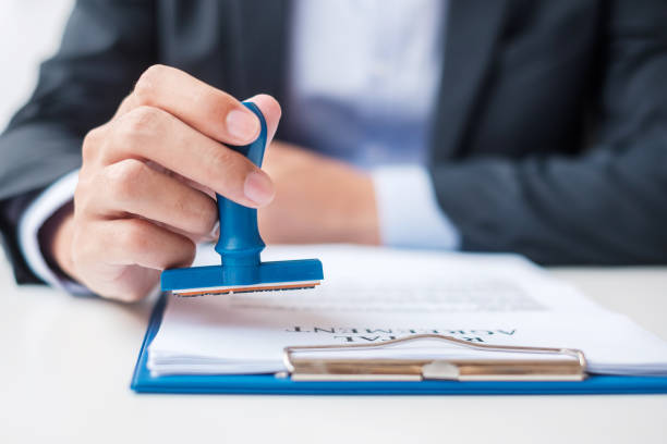 istock Businessman stamp during signing contract document.Business contract, approve, partnership, contract agreement and quality assurance concepts 1389631853