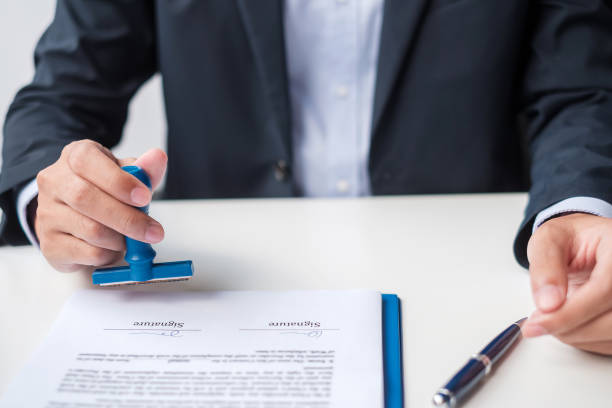 istock Businessman stamp during signing contract document.Business contract, approve, partnership, contract agreement and quality assurance concepts 1389631898