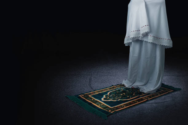 muzułmanka w zasłonie w pozycji modlącej się (salat) na dywanie modlitewnym - salah zdjęcia i obrazy z banku zdjęć