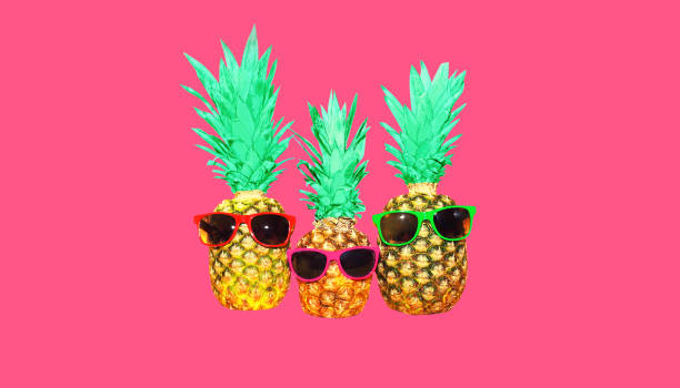 istock Pineapple with pink sunglasses on pink background, colorful ananas 1389633095