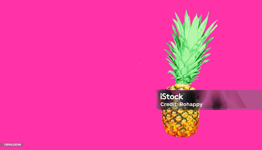Funny pineapple with sunglasses looking away on pink background, blank copy space for advertising text Fruit Stock Photo