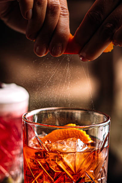 istock Sprinkling negroni cocktail from orange peel 1389634018