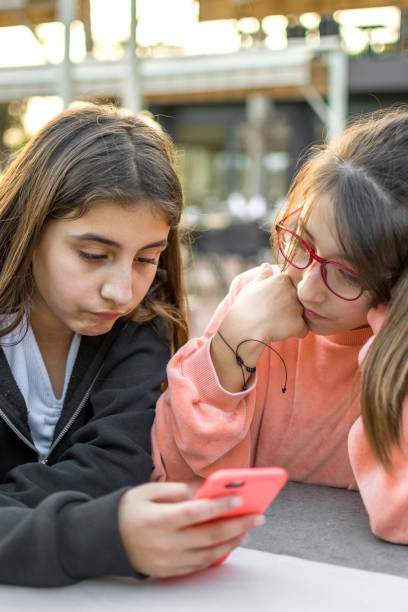 istock Beautiful Little girls using mobile phone 1389636461