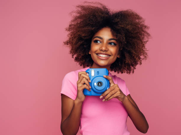 istock Happy beautiful woman with analog camera 1389641565