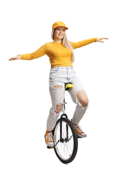 istock Young female riding a unicycle and smiling 1389642562