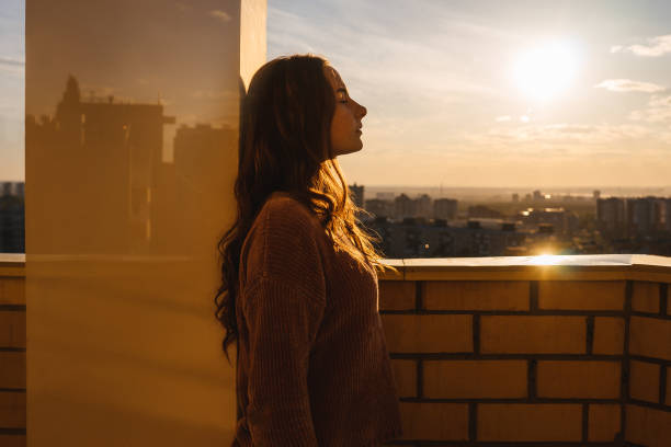istock Thoughtful woman with long hair on balcony. 1389642814