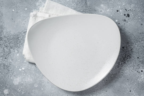 istock Empty white plate on table. Food cooking and healthy eating background. Gray background. Top view. Copy space 1389645690