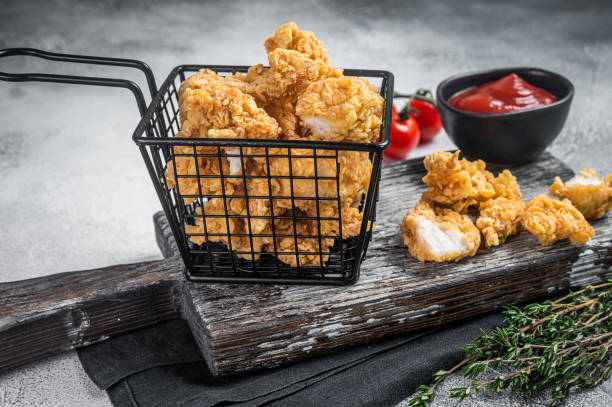 istock Dip Fried chicken popcorn with ketchup in a basket. White background. Top view 1389647241