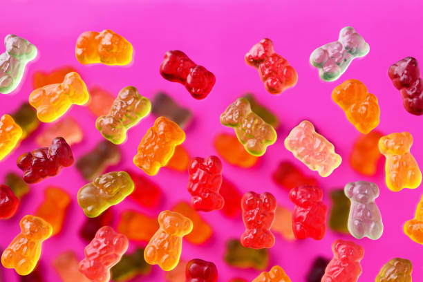 istock Multicolored flying gummy bears on a pink background, flat lay 1389647557