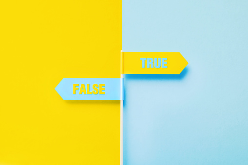 True and false written directional signs pointing opposite directions over yellow and blue background. Horizontal composition with copy space.