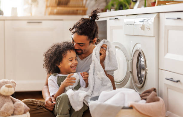 istock Son helping dad to load washing machine 1389648635