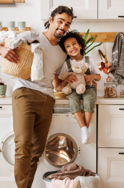 istock Happy father and son with laundry in kitchen 1389648900