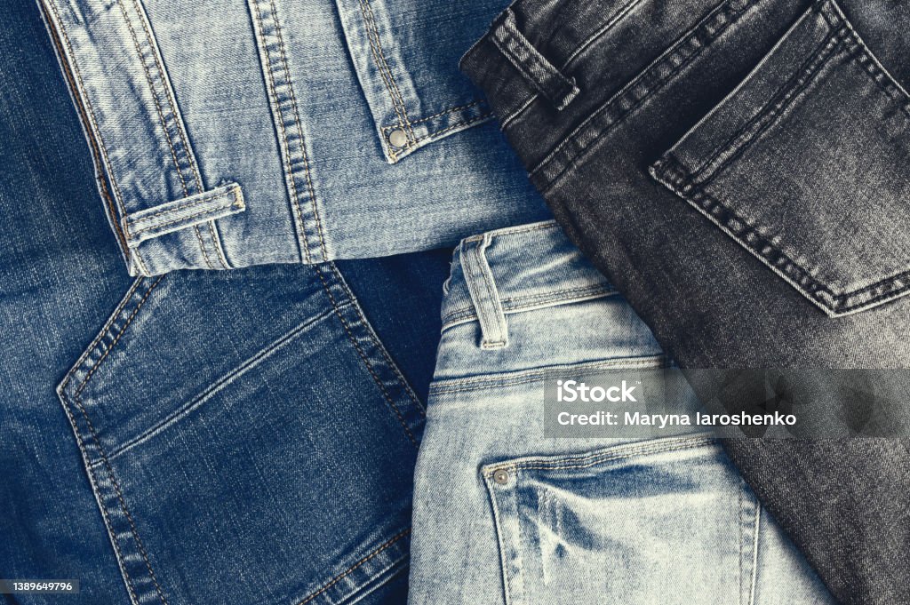 Variety of comfortable casual trousers, top view, copy space. Image with retro toning. Jeans Stock Photo