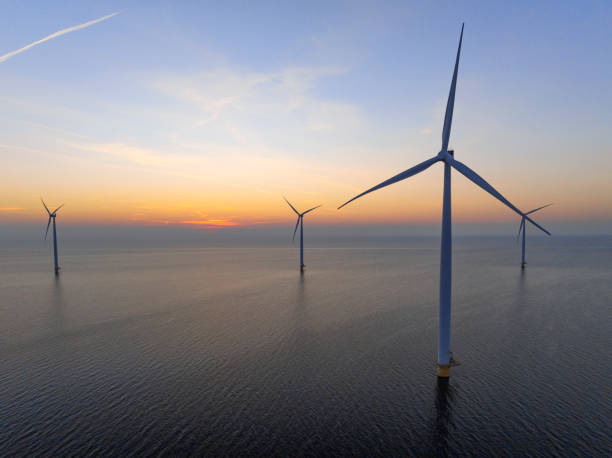 istock Wind turbines in an offshore wind park producing electricity during sunset. 1389649815