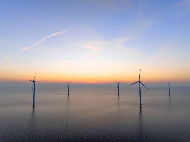 istock Wind turbines in an offshore wind park producing electricity during sunset. 1389649922